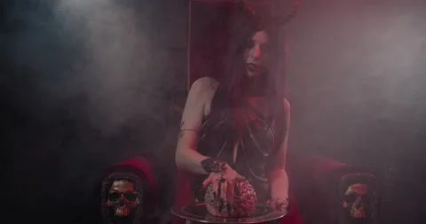 Succubus is sitting on the throne in hell and touching a human brain, 4k Stock Footage 136704796