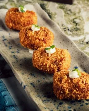 Succulent array of deliciously cooked Manchego Cheese Croquettes on a long tray Stock Photos