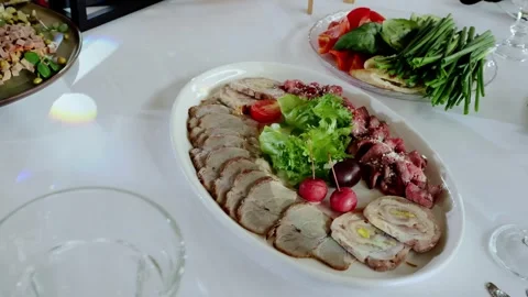 Succulent roast beef, meatloaf, and cured beef slices nestled on crisp white Stock Footage 336429243