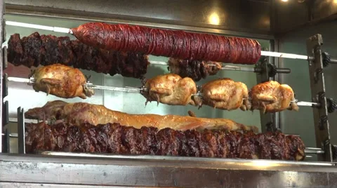 Succulent roasting pork, chicken, beef  meat on a rotisserie at a market, BBQ Stock Footage 30156092