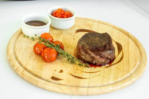 A succulent steak skillfully garnished with assorted sauces, fresh thyme, and Stock Photos