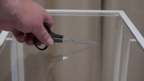 Sudden Clink: Black Scissors Accidentally Dropped onto Glass Table Surface. 動画素材 320809398