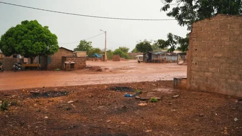 Sudden rain downpour over a rural dirt road in Prikro, Ivory Coast Stock Footage 340254461