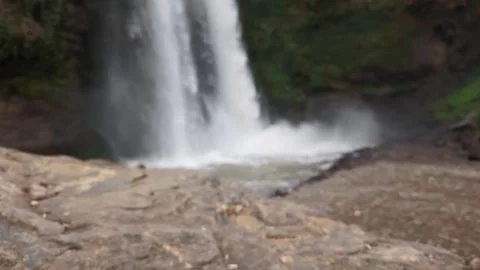 Sudden Upward Camera Movement from a Sharp Rock to a Blurred Waterfall 스톡 동영상 348158029