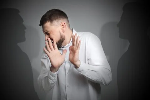 Suffering from hallucination. Scared man having delusion as shadows of peop.. Fotos de archivo