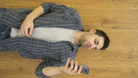 The suffering man lay on the floor and phone. View from above. Real time capture Stock Footage 70024807