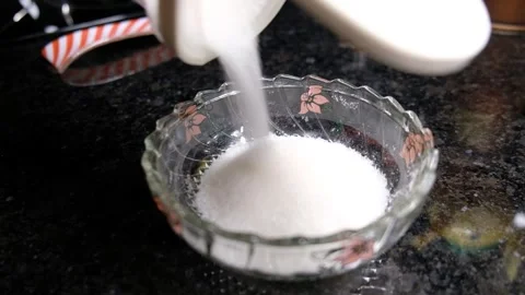 Sugar Being Poured from a Large Storage Container into an Empty Sugar Bowl on a Stock Footage 302687166