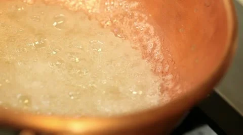 Sugar boiling to get caramel in a copper pot Stock Footage 11401117