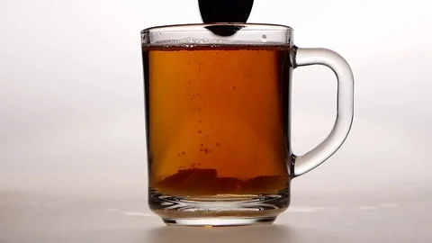 Sugar at the bottom of cup stir with spoon. White background Vidéo 73854666