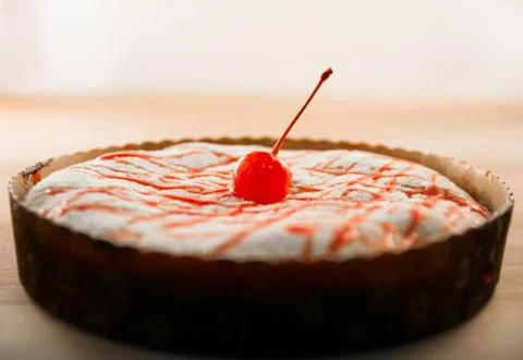 Sugar cherry on a delicious cheese cake Stock Photos