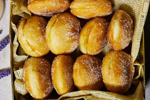 Sugar-Coated Jam Filled Doughnuts In Gift Box Styled On Newspaper Liner For Brea Stock Photos