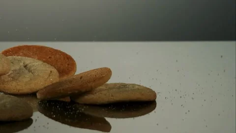 Sugar cookies falling on dark reflective surface Video stock 327052362