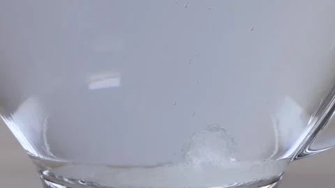 Sugar Crystals Dissolving in a Glass Mug of Hot Water Stock Footage 342488857