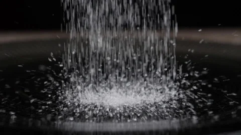 Sugar crystals fall on the black dish Stock Footage 109799174