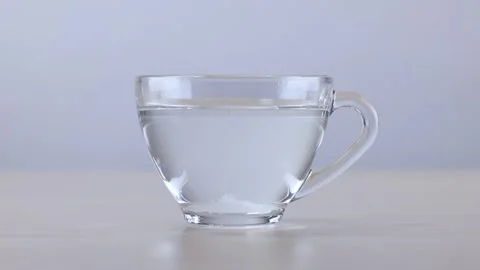 Sugar Cube Dissolving in Glass Cup of Hot Water Stock Footage 341853079