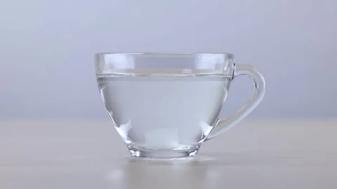 Sugar Cube Dissolving in a Glass Cup of Hot Water Stock Footage 341932808
