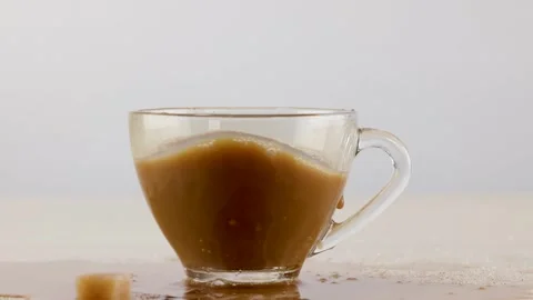 Sugar Cube Dropping into Glass Cup of Coffee with Milk Stock Footage 341642812