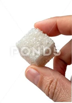 Sugar cube held between fingers against transparent background Modello PSD