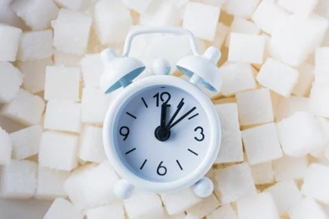 Sugar cube texture background sweet food ingredient and alarm clock Stock Photos