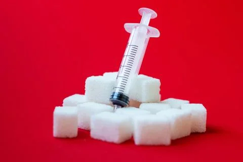 Sugar cubes and syringes on color background. Diabetes concept Stock Photos