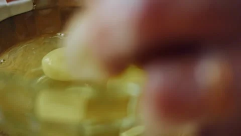 Sugar cubes dropping into a golden egg mixture, 4K Stock Footage 341119061