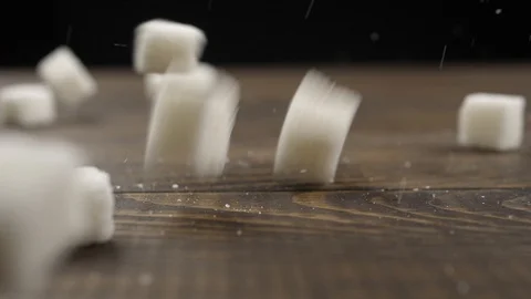 Sugar cubes fall on a wooden surface Stock Footage 109800483