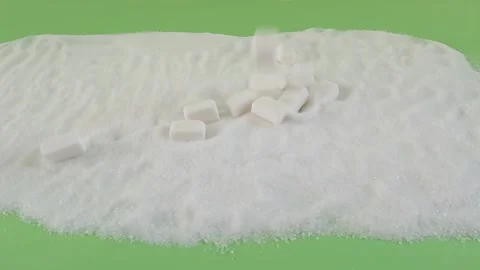 Sugar cubes falling down on the heap of refined white sugar on the green screen Stock Footage 293689756