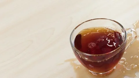 Sugar Cubes Falling Into Glass Cup of Black Tea Causing Splash Stock Footage 346013177