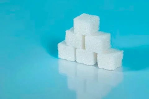 Sugar cubes on light blue background Stock Photos