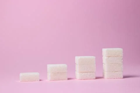Sugar cubes on a pink background.  Stock Photos