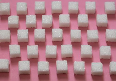 Sugar cubes on pink background Stock Photos