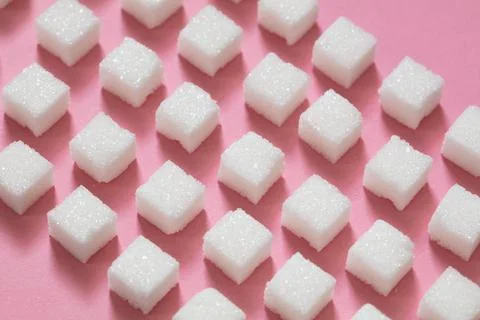 Sugar cubes on pink background Stock Photos