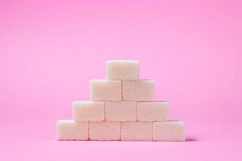 Sugar cubes on a pink background. Sugar pyramid. Stock Photos