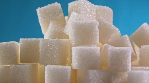 Sugar Cubes rotating on blue background close up Stockbeeldmateriaal 122257158