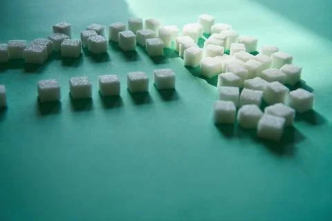 Sugar cubes scattered on green surface Foto stock