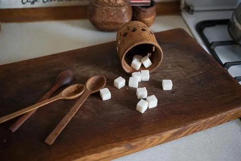 Sugar in cubes scattered on the kitchen board Stock Photos