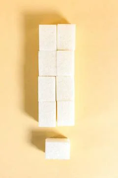 Sugar cubes in the shape of an exclamation mark on a beige background. Foto stock
