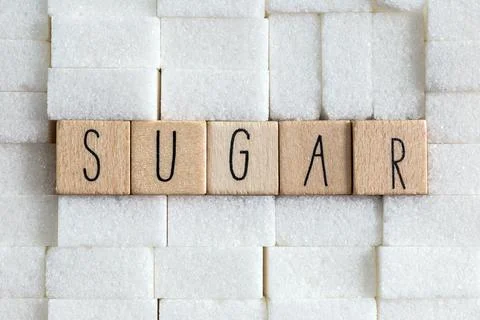 Sugar cubes wall with the text Sugar on brown natural background texture, Health Stock Photos