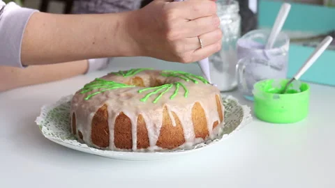 Sugar cupcake decorated with green elements. Woman adds items with a pastry b Stock Footage 130603148