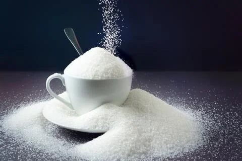 Sugar on a dark background with a spoon. Concept of harm health Stock Photos