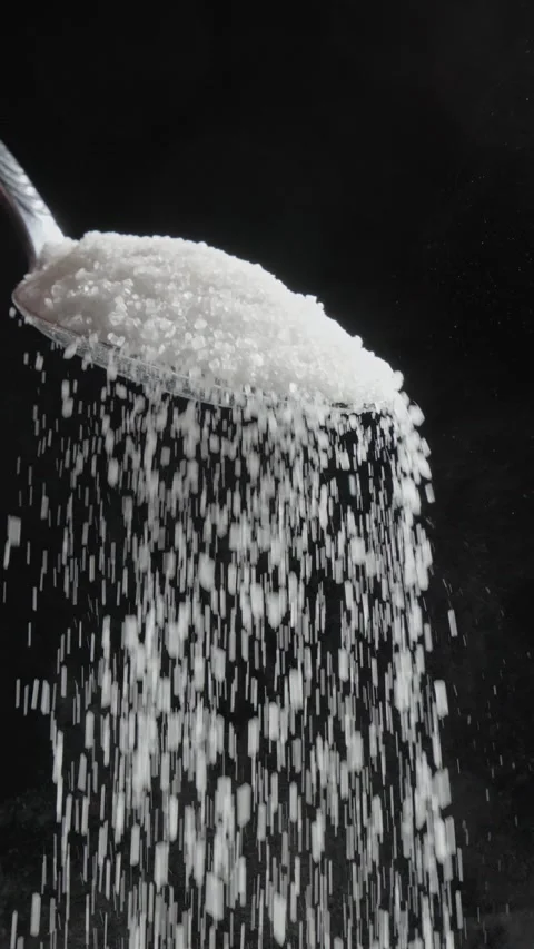 Sugar is falling down from silver spoon at black background. Stock Footage 330773317