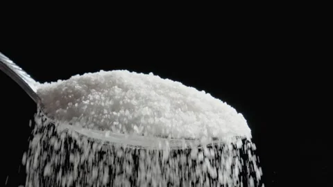 Sugar falling down from silver spoon black background. Grains of natural sugar Stock Footage 331241239