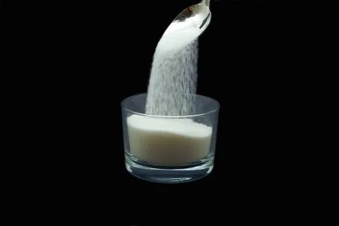 Sugar falling from spoon medium speed Stock Photos