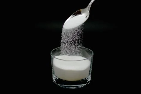 Sugar falling from spoon Stock Photos