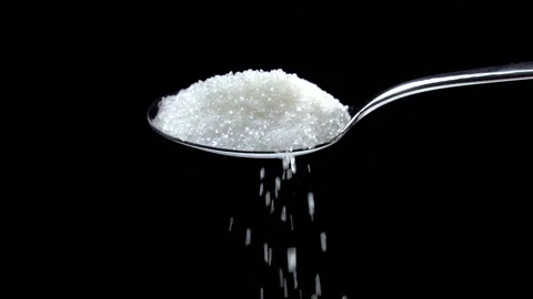 Sugar falling from spoon in slow motion on black background Stock Footage 165168961