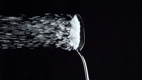 Sugar falling from spoon in slow motion on black background. Vertical video Stock-Footage 165408641