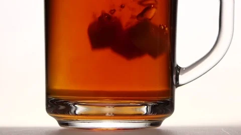 Sugar falls to the bottom of cup tea. Close ups Stock Footage 73853773