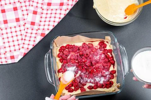 Sugar falls on the cherries. The process of preparing a berry pie Stock Photos