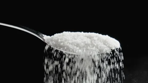 Sugar flows gracefully from spoon into void, showcasing its delicate texture 库存影片 329435673