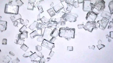 Sugar granules under a microscope, close-up. Isolated White background. Stock Photos